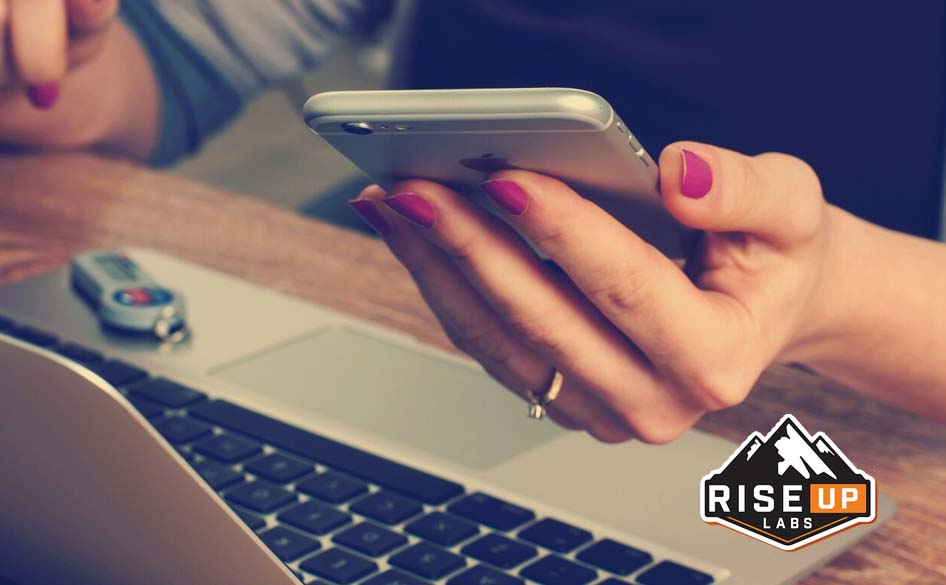 a girl holding a mobile and laptop