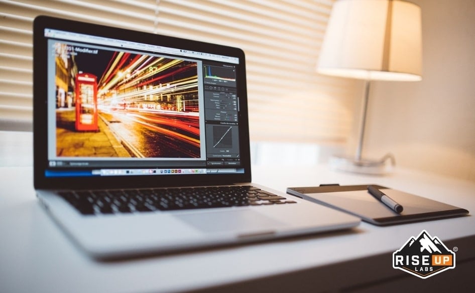 laptop on a desk with a photo editing software